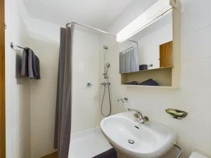 un bagno bianco con lavandino e doccia di Panorama hideaway apartment near Zermatt with parking! a Täsch