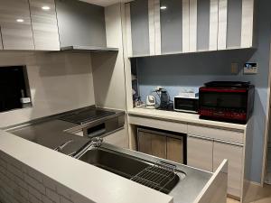 a kitchen with a sink and a microwave at JL 東京 House - 駐車場付き築浅のまるごと貸切住宅 in Tokyo