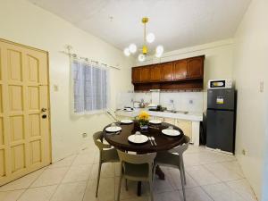 a kitchen with a table and a black refrigerator at AisG Homestay Tres -Fully Furnished Shared Homestay FREE NETFLIX-3mins to Airport in Puerto Princesa City +15 photos