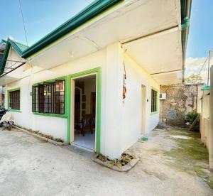 a white building with a green door on it at AisG Homestay Tres -Fully Furnished Shared Homestay FREE NETFLIX-3mins to Airport in Puerto Princesa City