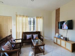 a living room with chairs and a table and a tv at AisG Homestay Tres -Fully Furnished Shared Homestay FREE NETFLIX-3mins to Airport in Puerto Princesa City