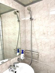 Un baño con ducha con lavabo y espejo. en Rise and Shine, Seoul, en Seúl
