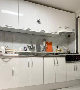 Una cocina con gabinetes blancos y un fregadero. en Rise and Shine, Seoul, en Seúl