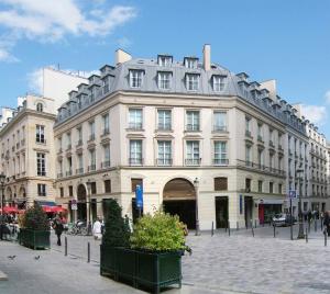 un gran edificio blanco en una calle de la ciudad en Residhome Paris Opéra, en París
