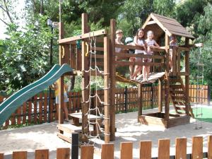 a group of children playing on a wooden playground at Family Resort Cala di Luna in Marina di Camerota
