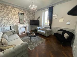 a living room with a couch and a chair at Le Domaine de la Garenne in Épinac-les-Mines