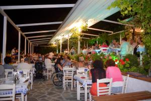 a group of people sitting at tables in a restaurant at Olympos Beach in Plaka Litochorou