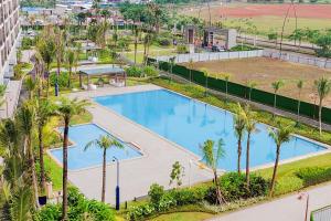 eine Draufsicht auf einen Swimmingpool mit Palmen in der Unterkunft Best Choice and Cozy Studio Sky House BSD Apartment By Travelio in Tangerang