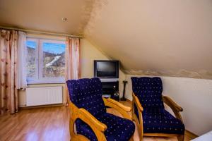 a living room with two chairs and a television at Apartament u Zosi Krościenko in Krościenko