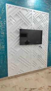 eine weiße Wand mit einem Fernseher daran in der Unterkunft The Marker in Tehla + 26 Fotos