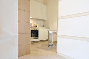 una cucina con mobili bianchi e un tavolo di Vigna Nuova Suites a Firenze
