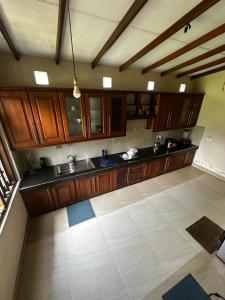 an empty kitchen with wooden cabinets and a floor at Curve Hiri in Dickwella