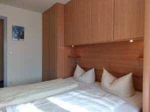 a bedroom with a bed with white sheets and pillows at 2-Raum FeWo Gipfelglück - Hallenbad & Sauna in Fischen +6 photos