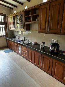 a kitchen with wooden cabinets and a black counter top at Curve Hiri in Dickwella +59 photos