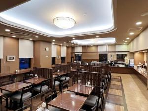 a dining room with wooden tables and chairs at Hotel Route-Inn Ichinoseki Inter in Ichinoseki