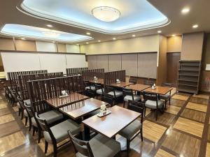 a dining room with wooden tables and chairs at Hotel Route-Inn Ichinoseki Inter in Ichinoseki
