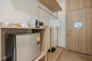 ein kleiner Kühlschrank in einem Zimmer mit Holztür in der Unterkunft Parima Hotel in Trang