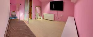 an empty room with pink walls and a television at Urban Residence in Bacău