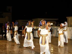 Un groupe de personnes qui dansent sur scène dans l'établissement House Of Life Abydos, à Abydos