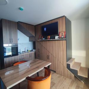 a kitchen with a wooden table and a dining room at Fortuna Royal in Kopaonik