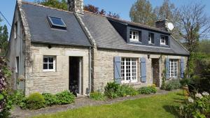 an old stone house with a black roof at le moulin in Pont-Croix