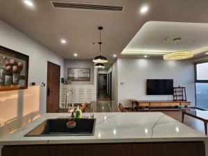 a kitchen with a sink and a living room at Căn Hộ 3 Phòng Ngủ Siêu Sang Trọng Tại The Matrix One in Hanoi +13 photos