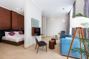 a bedroom with a bed and a couch and a tv at S Loft Manado in Manado +120 photos