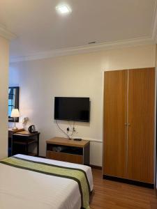 a hotel room with a bed and a flat screen tv at Hotel Chua Gin @ Brinchang Centre in Brinchang +15 photos