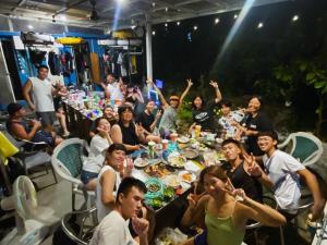 a group of people sitting at a table eating food at Lambay Island in Xiaoliuqiu