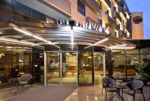 伯薩的住宿－蒂拉溫泉&SPA酒店，大楼前设有桌椅的餐厅