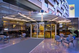 a restaurant with tables and chairs in front of a building at Tiara Thermal & SPA Hotel in Bursa