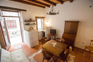 sala de estar con mesa de madera y cocina en Bilocale Mandralisca, en Cefalú