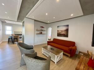 a living room with a red couch and chairs at Central Apartment near Jetty Swakopmund in Swakopmund