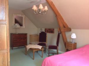 a bedroom with a bed and a table and chairs at le petit clos in Baugé-en-Anjou +19 photos