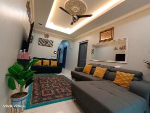 a living room with a couch and a ceiling fan at HANS HOMESTAY in Lumut