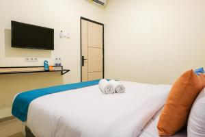 Postel nebo postele na pokoji v ubytování Sans Hotel Beskalan Malioboro