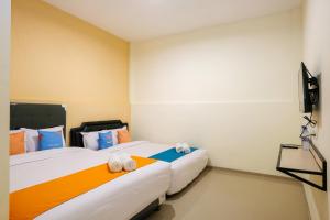 Postel nebo postele na pokoji v ubytování Sans Hotel Beskalan Malioboro