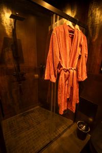 an orange robe hanging in a shower in a bathroom at Spa Rust Room in Berstett