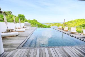 泰尔斯贝斯delightful vacation Villa Crystal St Martin的木制甲板上带躺椅的游泳池