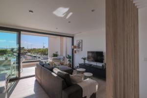 a living room with a couch and a large window at Luxury Penthouse - Santa Rosalia Lake and Life Resort in Torre-Pacheco
