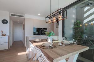 a kitchen and dining room with a table and chairs at Luxury Penthouse - Santa Rosalia Lake and Life Resort in Torre-Pacheco