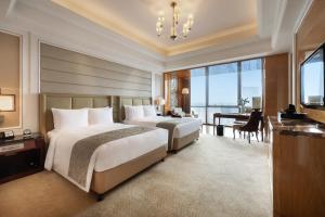 a hotel room with two beds and a desk and a desk at The Ritz-Carlton, Chengdu in Chengdu