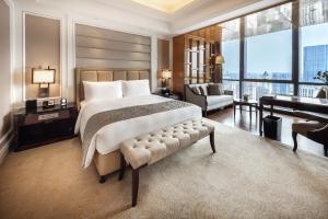 a bedroom with a large bed and a piano at The Ritz-Carlton, Chengdu in Chengdu