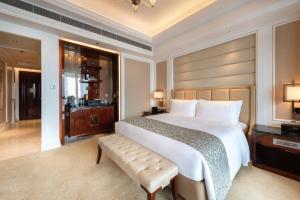a bedroom with a large white bed and a bench at The Ritz-Carlton, Chengdu in Chengdu