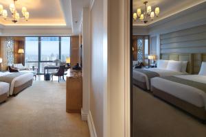 a hotel room with two beds and a living room at The Ritz-Carlton, Chengdu in Chengdu