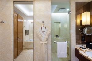 two views of a bathroom with a shower and a sink at The Ritz-Carlton, Chengdu in Chengdu