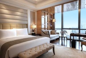 a bedroom with a large bed and a desk at The Ritz-Carlton, Chengdu in Chengdu