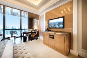 a living room with a flat screen tv and a desk at The Ritz-Carlton, Chengdu in Chengdu