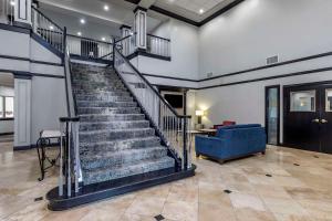 a staircase in a living room with a blue couch at Quality Inn & Suites I-35 E-Walnut Hill in Dallas