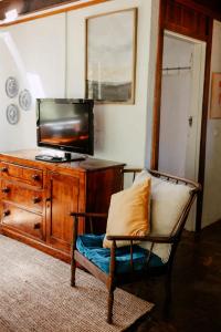 a living room with a tv and a chair at Cottage 1 - The Row in Forest Grove +30 photos